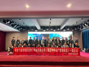 Group photo of professionals at COSMICONN event on stage holding a red banner, in a conference hall.
