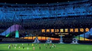 Asian Games 2023 Hangzhou opening ceremony at stadium with colorful lights and large digital display.