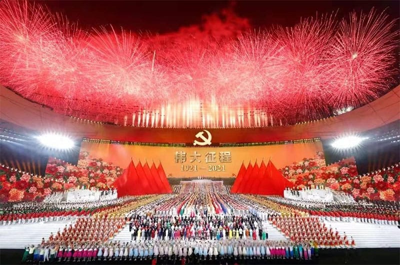 Vivid fireworks display over a large celebration stage with Communist Party symbols for COSMICONN event.
