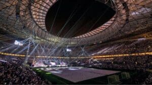 Spectacular indoor stadium during a live esports or gaming event, with dynamic lighting and large crowd.
