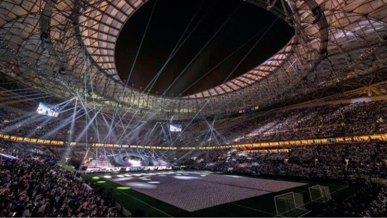 Spectacular indoor stadium during a live esports or gaming event, with dynamic lighting and large crowd.