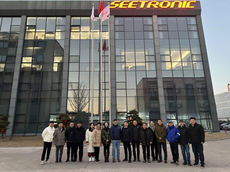 SEETRONIC building facade with group of employees outside, modern corporate headquarters.