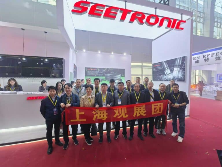 High-tech exhibition booth of SEETRONIC at Cosmiconn trade fair with a group of professionals.