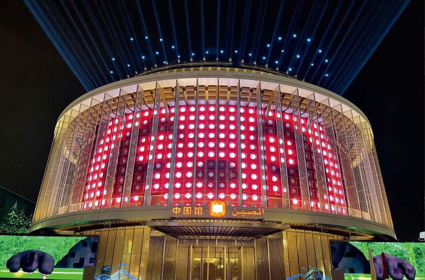 Bright LED display on a modern building at night, showcasing advanced digital architecture and illuminations for COSMICONN event.